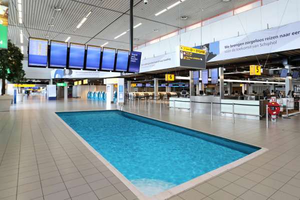 Wachtende reizigers op Schiphol blij met zwembad in vertrekhal